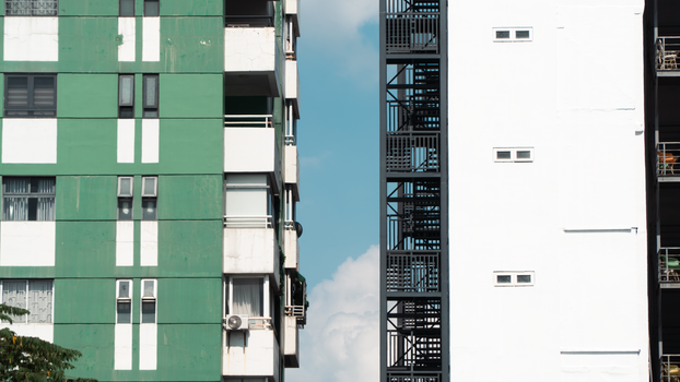 Urban architecture featuring contrasting building facades under a clear blue sky.