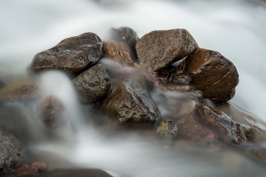 Smooth flowing water over rocks captured in long exposure style.