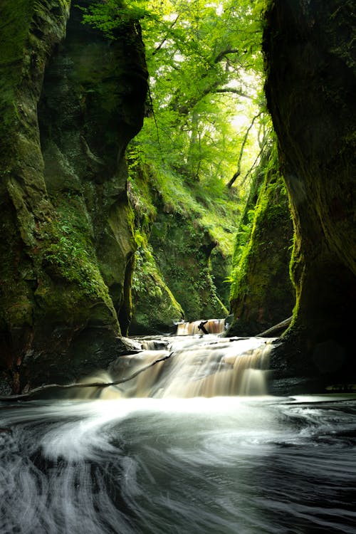 Time-Lapse Photo of River Between Mossy Rocks