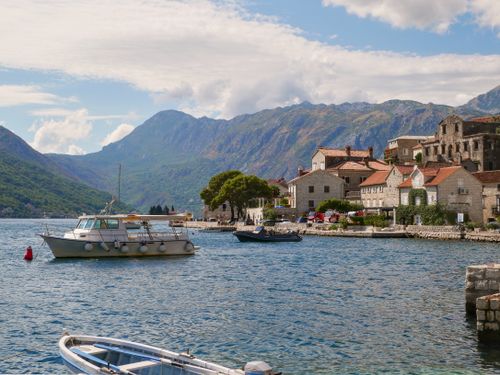 Free Picturesque Kotor Bay scene with boats, mountains, and historic buildings under a bright sky. Stock Photo