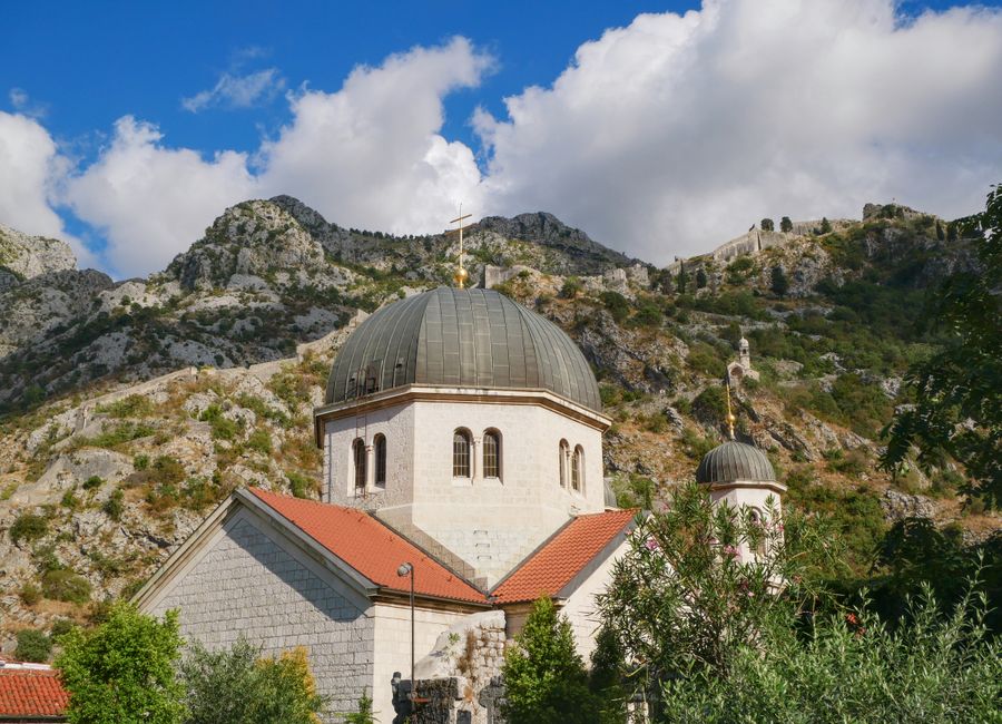 Picturesque church nestled against the rugged mountains of Kotor, Montenegro.