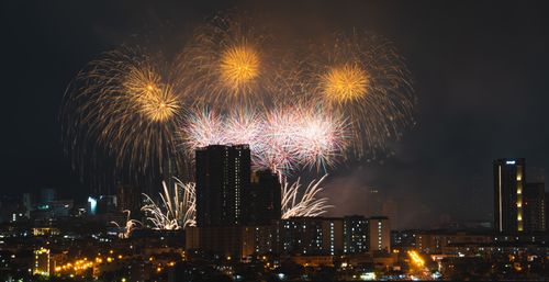 Free A stunning fireworks show lights up the night sky above a bustling city skyline. Stock Photo