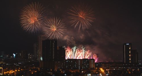 Free Spectacular fireworks illuminate the city skyline at night with vibrant colors and stunning patterns. Stock Photo