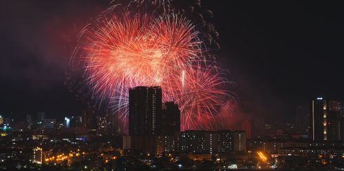 Free Spectacular fireworks illuminate a city's night skyline, creating a vibrant and festive scene. Stock Photo