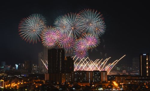 Free Vibrant fireworks illuminate a city skyline during a nighttime celebration, showcasing colorful bursts. Stock Photo