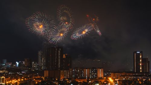 Free Spectacular fireworks display illuminating the night sky over a bustling cityscape. Stock Photo