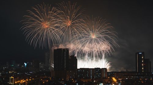 Free Dazzling fireworks light up the night sky above a vibrant city skyline, creating a magical atmosphere. Stock Photo