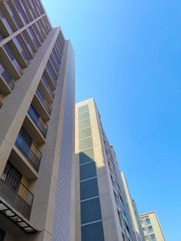 View of modern high-rise buildings reaching towards a clear blue sky, showcasing urban architecture.