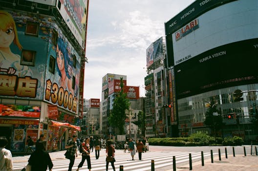 Bustling urban street in Shinjuku, Tokyo showcasing Japanese culture and vibrant billboards.