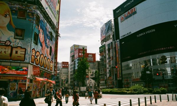 Bustling urban street in Shinjuku, Tokyo showcasing Japanese culture and vibrant billboards.