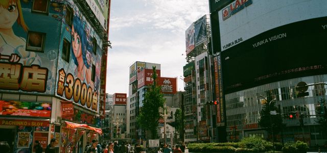 Bustling urban street in Shinjuku, Tokyo showcasing Japanese culture and vibrant billboards.