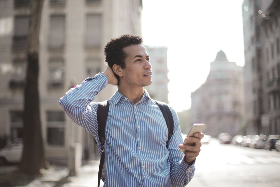 Nadenkende Man Met Smartphone Op Straat