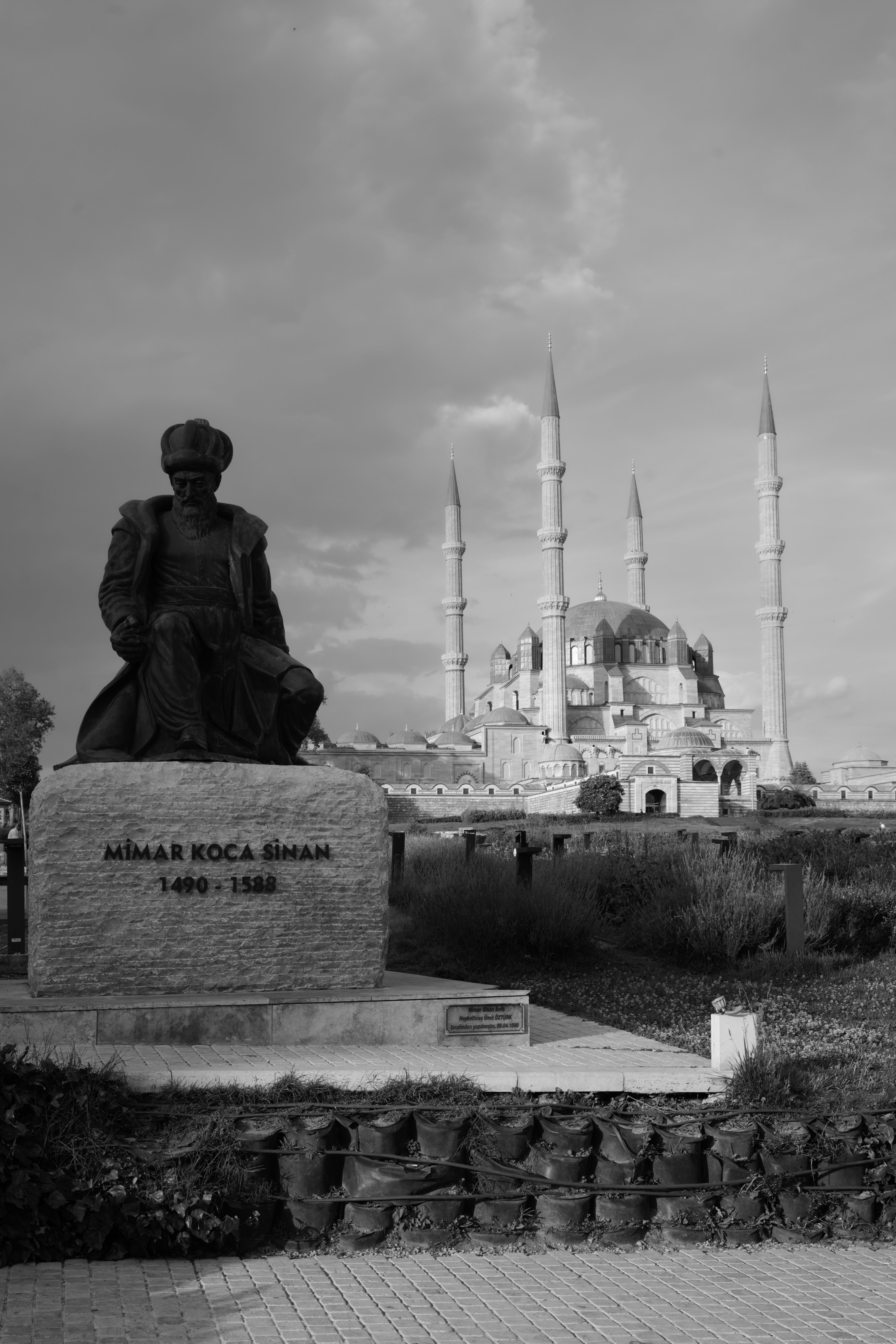 Black-and-white photo of Selimiye Mosque and Mimar Sinan statue in Edirne, Türkiye.