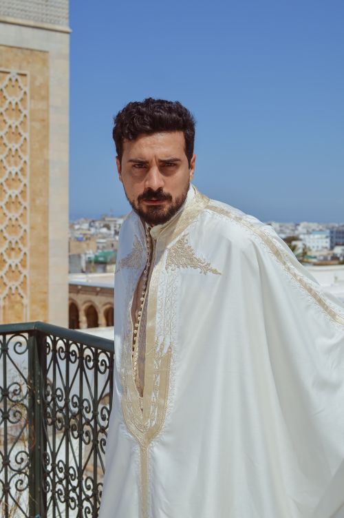 Free A man wearing traditional attire stands on a rooftop in Tunisia. Stock Photo
