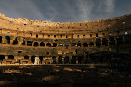Free Capture of Rome's historic Colosseum interior with dramatic lighting at sunset. Stock Photo