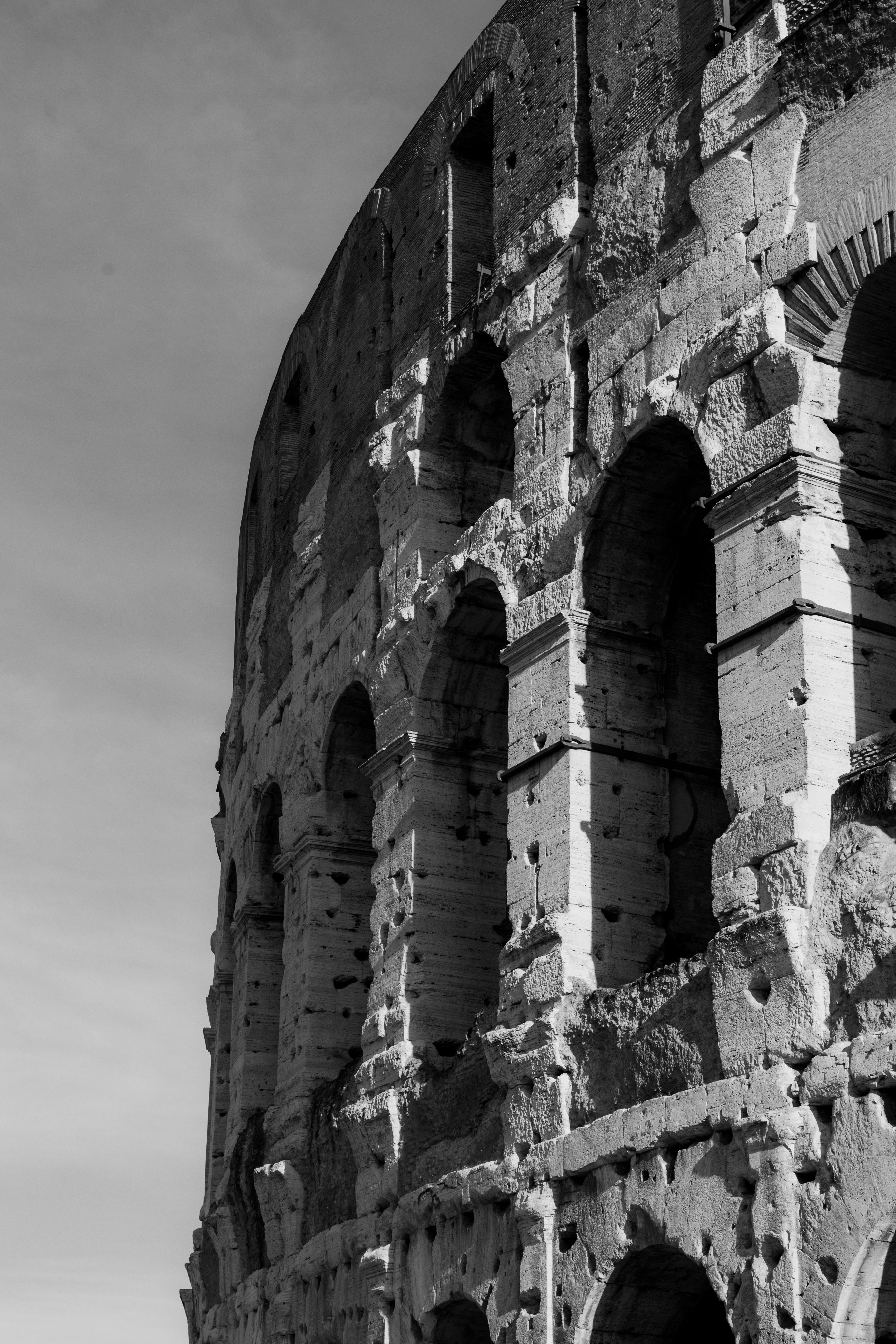 Monochrome view of the iconic Colosseum showcasing its ancient architectural beauty in Rome, Italy.