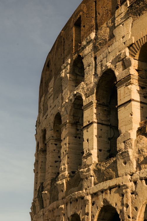 Free Close-up of the ancient Roman Colosseum exterior at sunset, showcasing architectural details. Stock Photo