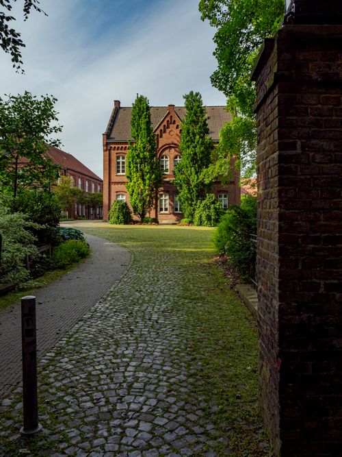 Free Charming cobblestone path leading to a historic brick building in Coesfeld, Germany. Stock Photo