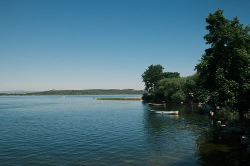 Free Tranquil scene of a lake with boats and trees in Bursa, Türkiye, under a clear blue sky. Stock Photo