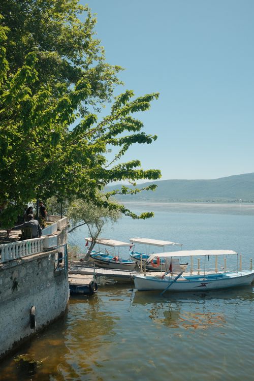 Free Peaceful lakeside view in Bursa, Turkey featuring moored boats under a clear blue sky. Stock Photo