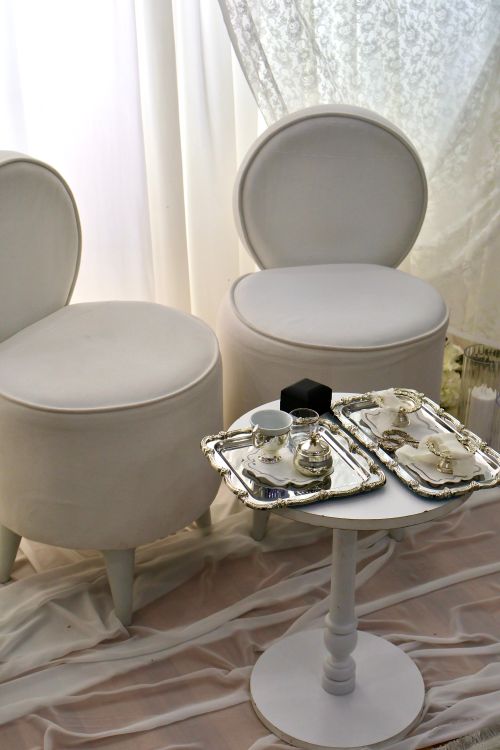 Free Luxury tea setup with white chairs and silverware on a round table, creating a serene ambiance. Stock Photo