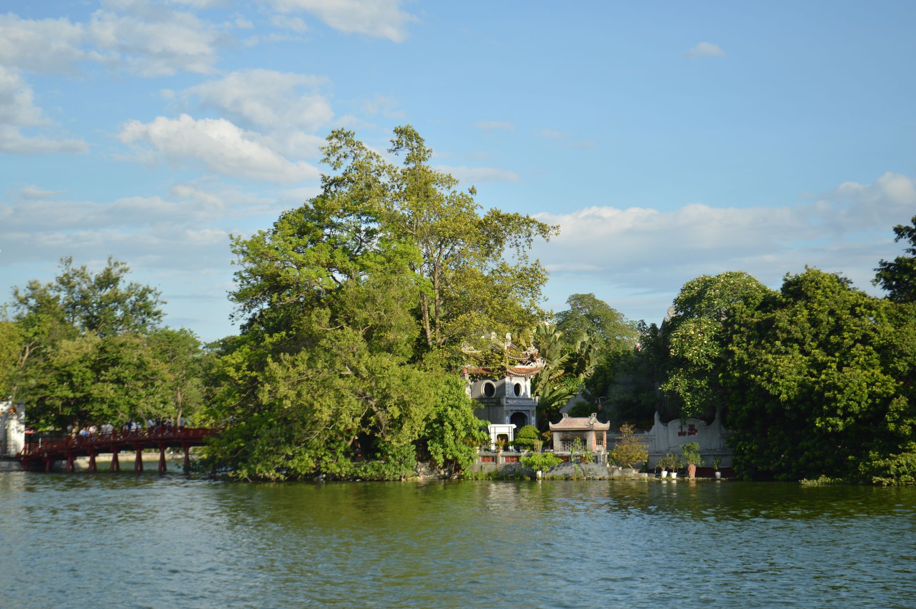 The red Huc Bridge and the tree-covered Ngoc Son Temple island on Hoan Kiem Lake, Hanoi
