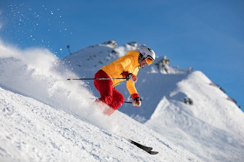 노란색 재킷과 빨간 바지 스키를 타는 사람