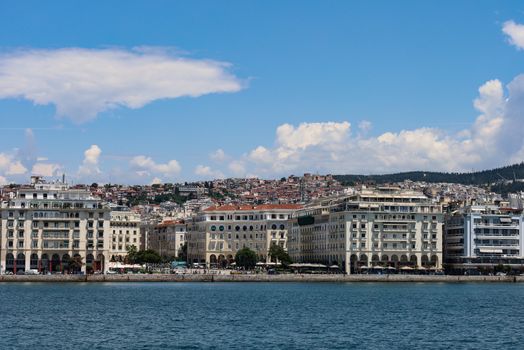 Scenic view of Thessaloniki's iconic waterfront buildings against a bright summer sky.
