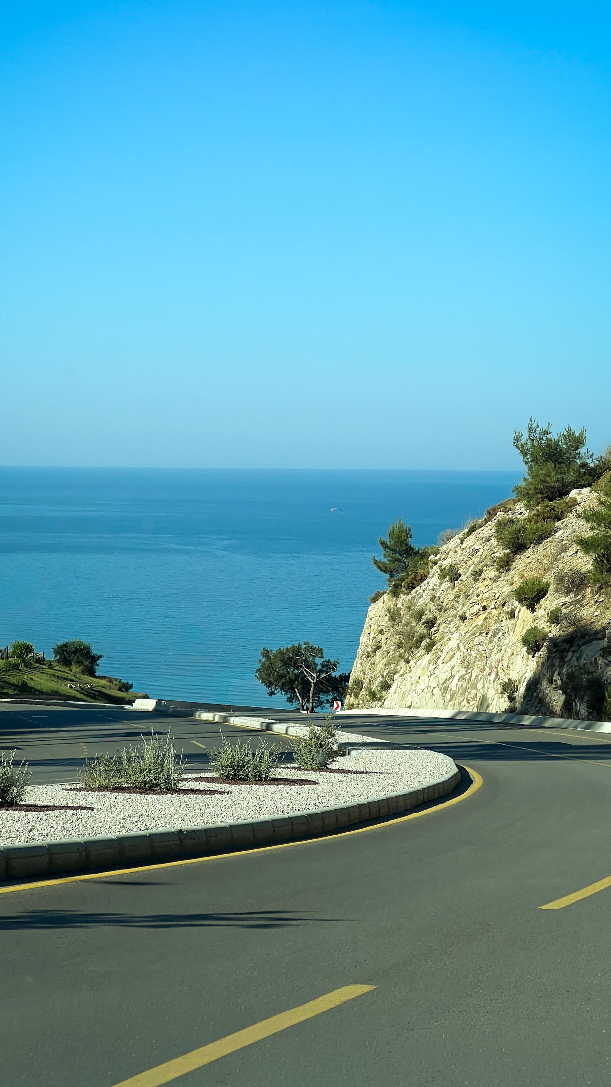Serene coastal road overlooking the turquoise sea in Ölüdeniz, Türkiye. Ideal for travel and nature imagery.