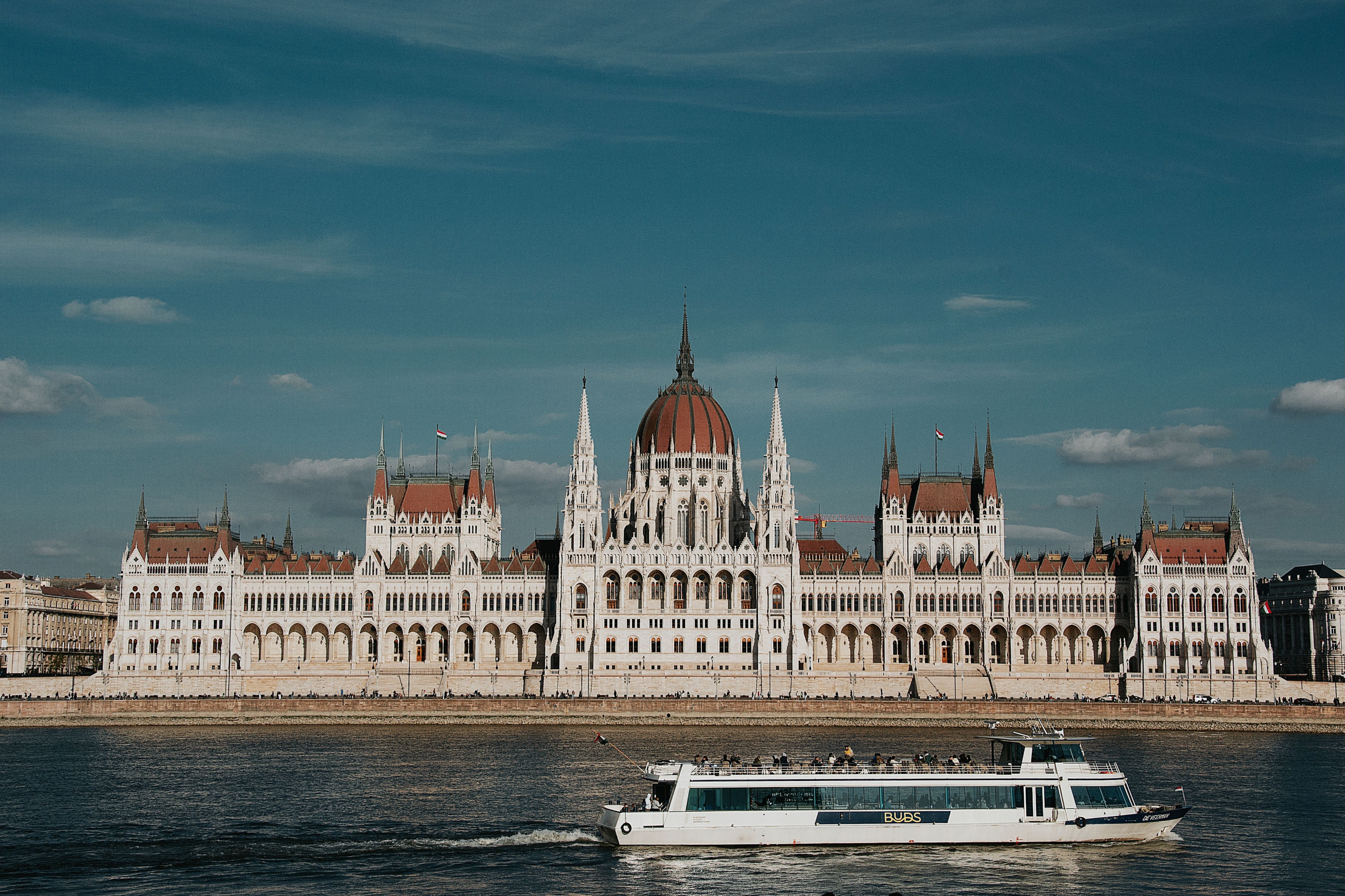 Scenic view of the Hungarian Parliament Building in Budapest with a riverboat on the Danube.