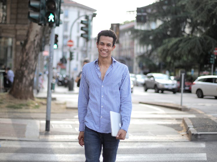 Positive Young Male Crossing Road