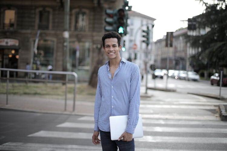 Happy Man With Netbook Standing On Crossroad