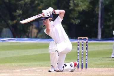 A batter playing a stroke in front of the wicketkeeper