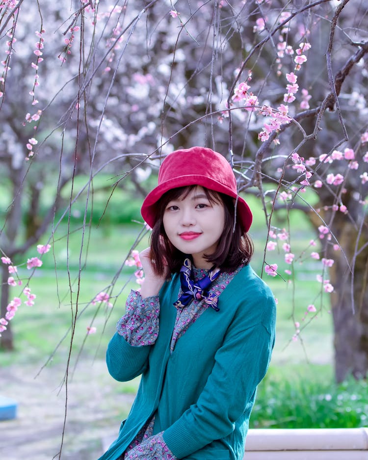 Young Smiling Ethnic Woman Resting In Garden On Spring Day