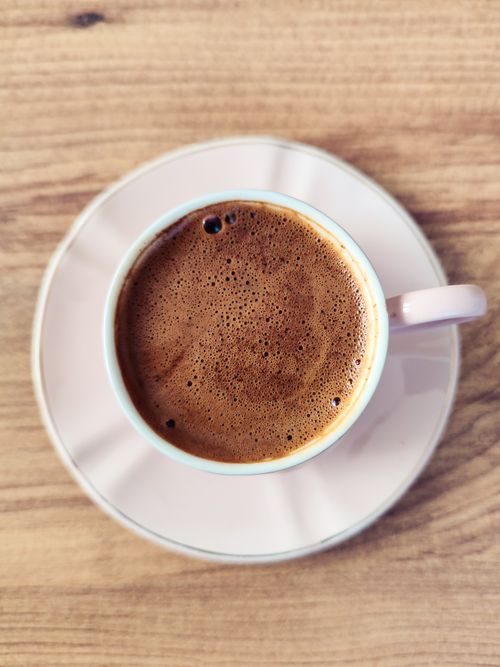 Free Top view of a cup of freshly brewed coffee on a wooden table. Perfect for coffee lovers. Stock Photo