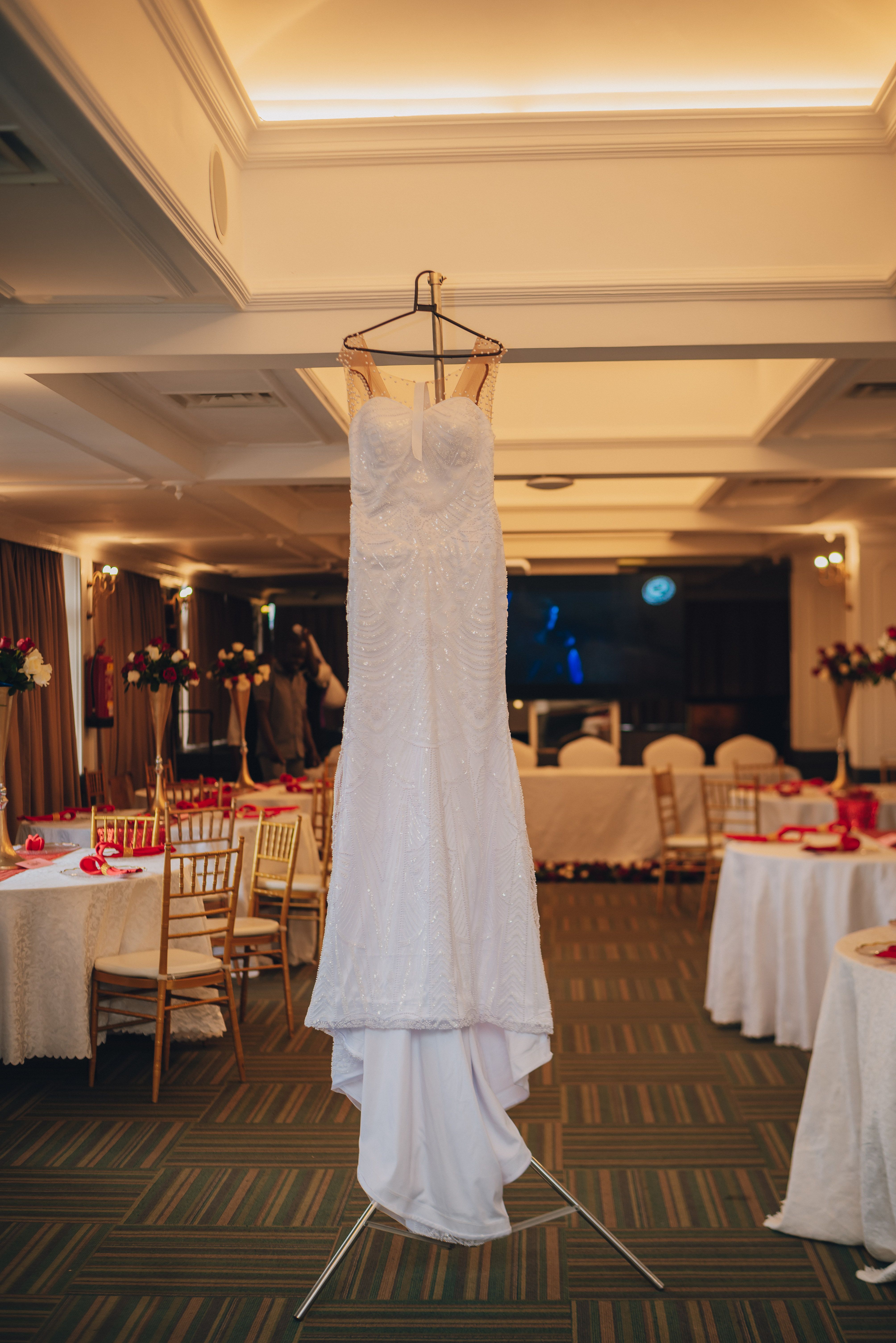 Beautiful wedding dress hanging in Nairobi reception hall, ready for a special day.