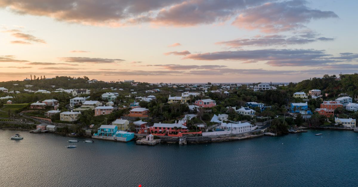 Viajera usando una eSIM en Bermudas con una playa de arena rosa al fondo