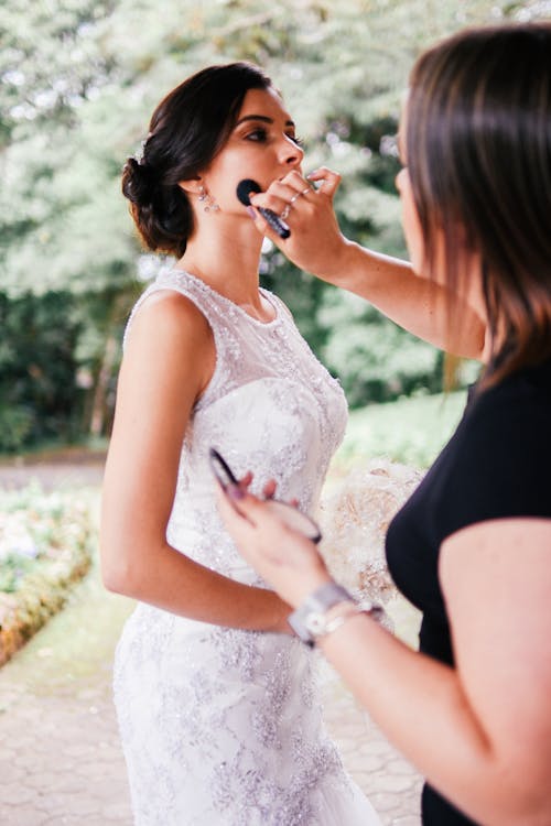 Woman Fixing a Bride's Makeup