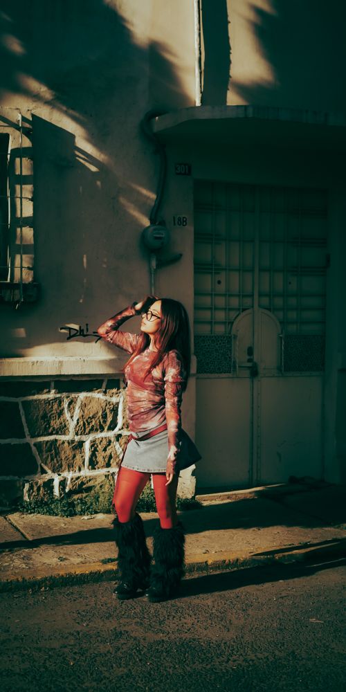 Free Fashionable woman posing with sunlight casting shadows on the street. Stock Photo