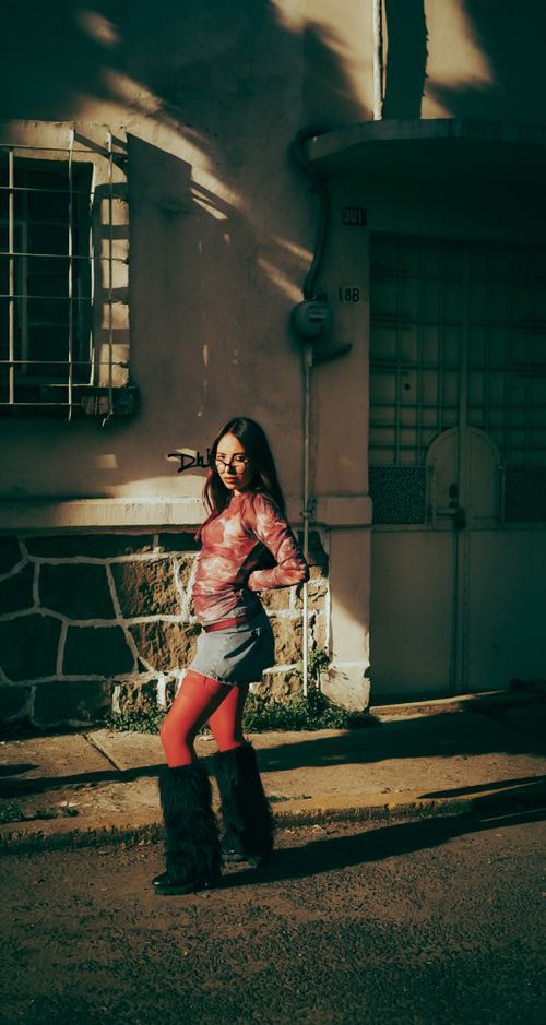 Free Stylish woman in chic outfit poses confidently on a sunlit city street. Stock Photo