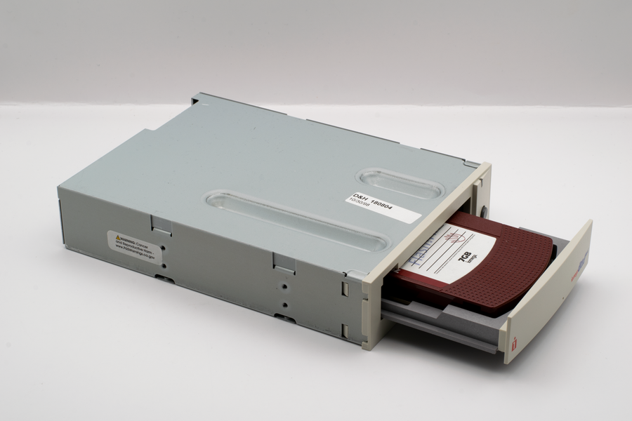 Vintage 1990s removable disk drive with a diskette inserted, isolated on white.
