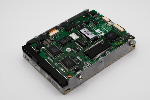 Close-up of a vintage hard drive circuit board showcasing intricate electronic components.