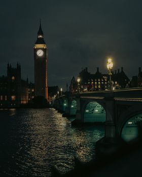 Dramatic night view of Big Ben and Westminster Bridge in London, England, beautifully illuminated.