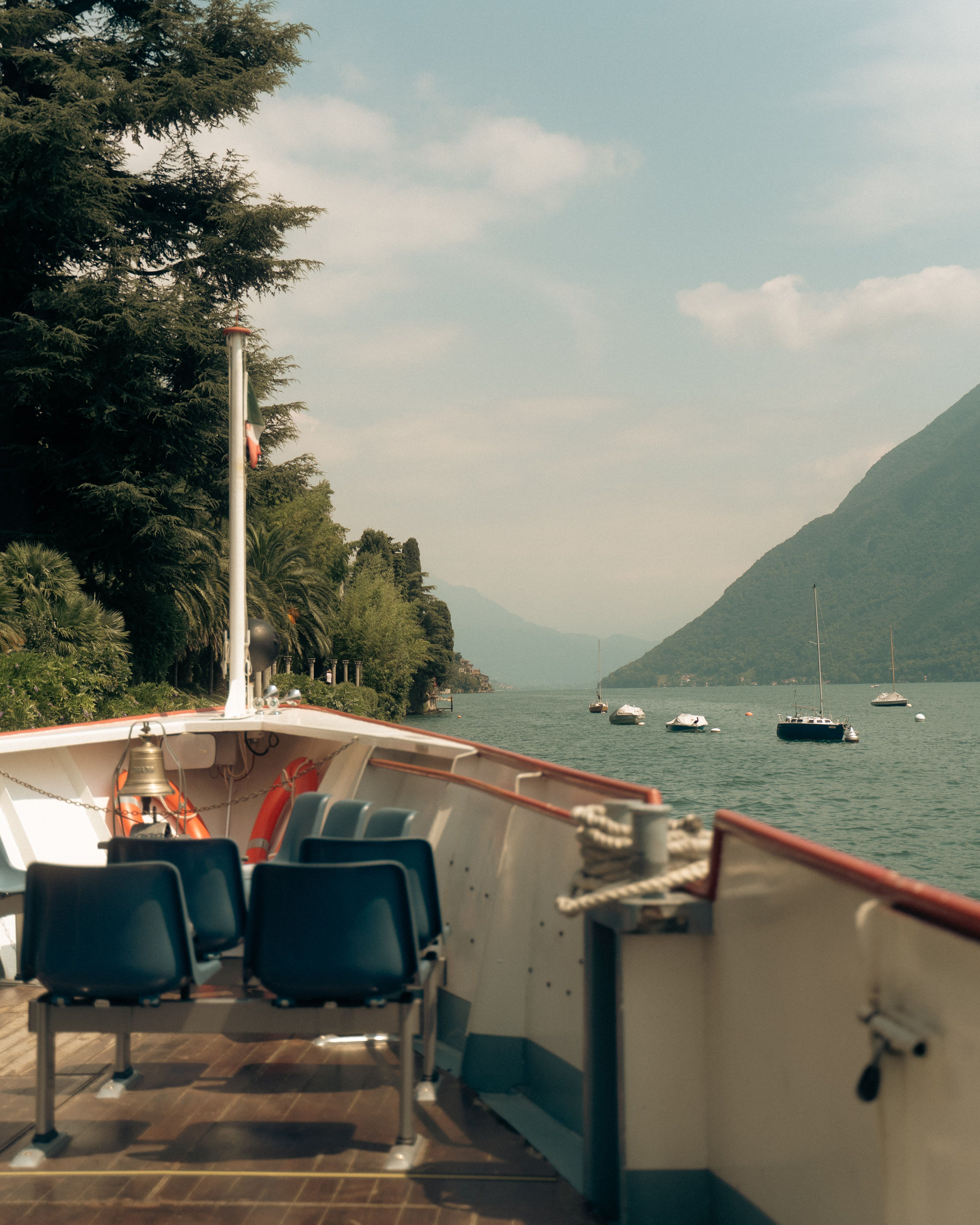 Calm boat ride with a view of Lake Lugano in Ticino, Switzerland, featuring serene waters and mountains.