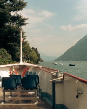 Calm boat ride with a view of Lake Lugano in Ticino, Switzerland, featuring serene waters and mountains.
