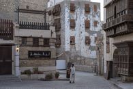 A man walks along a historic street in Al-Balad, Old Jeddah, showcasing traditional architecture.