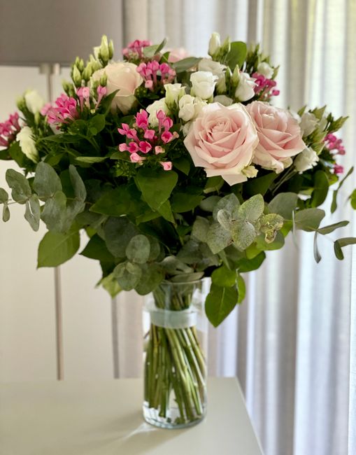 Arreglo floral mixto con rosas y eucalipto en jarrón transparente