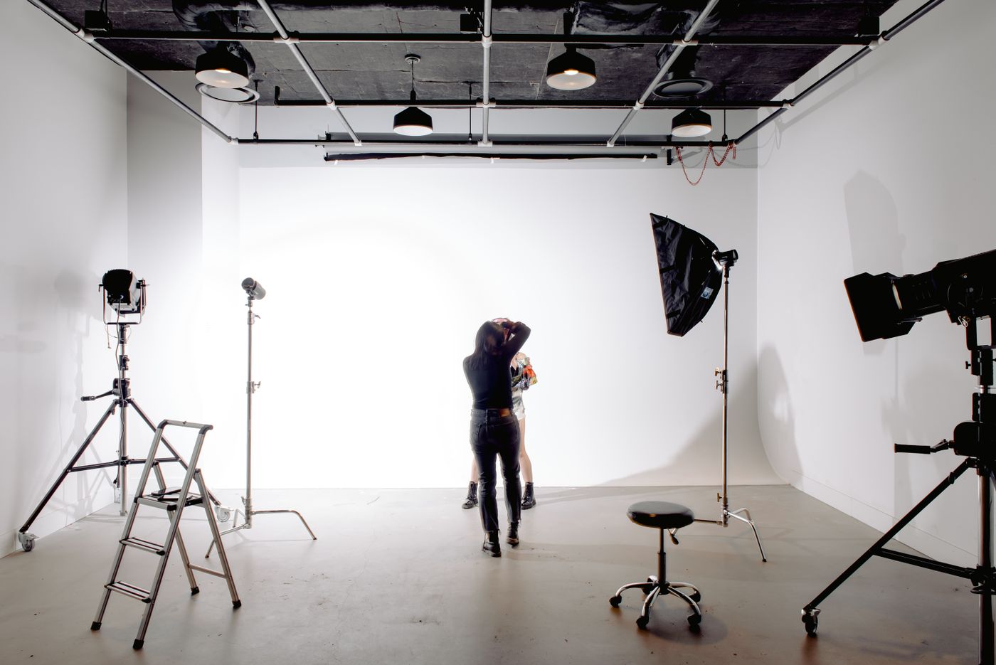 Photographer shooting a model in a light-filled studio