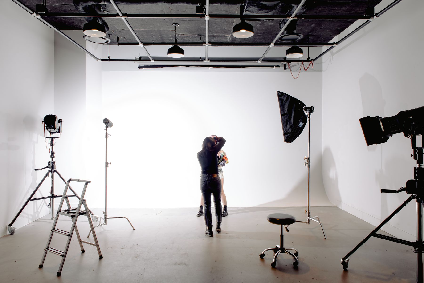 Photographer shooting a model in a light-filled studio