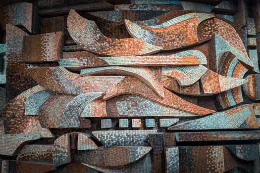 Explore this detailed mosaic wall with abstract patterns and earthy colors.